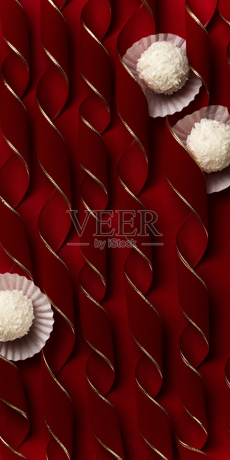 椰子果仁糖天鹅绒红色弯曲的鞋带，节日的甜点背景概念照片摄影图片