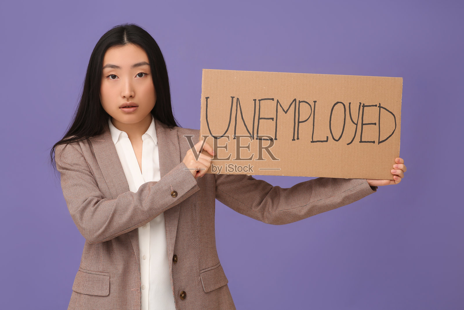 亚洲妇女举着紫色背景的“失业”字样的牌子照片摄影图片