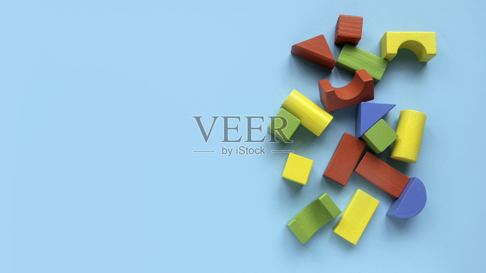 教育玩具，认知技能，儿童发展。彩色蒙台梭利几何形状的玩具在蓝色的背景。照片摄影图片