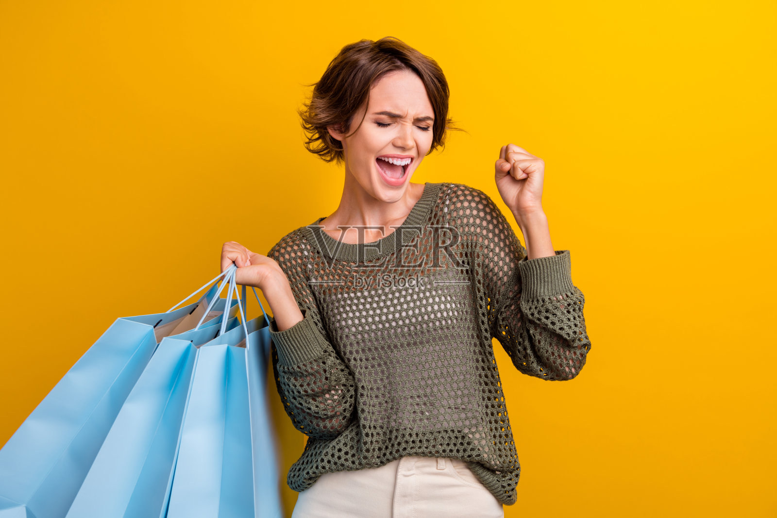 照片中的女孩穿着时髦的衣服庆祝秋季特卖，背景是鲜艳的黄色照片摄影图片