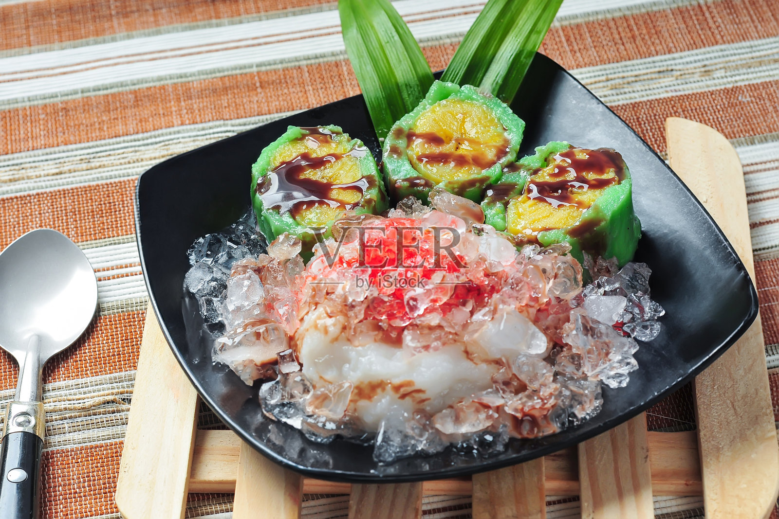 Es Pisang Ijo是印度尼西亚南苏拉威西岛望加锡的传统甜点，由香蕉和小麦粉、米粉和椰奶混合而成。与泥和糖浆一起食用照片摄影图片