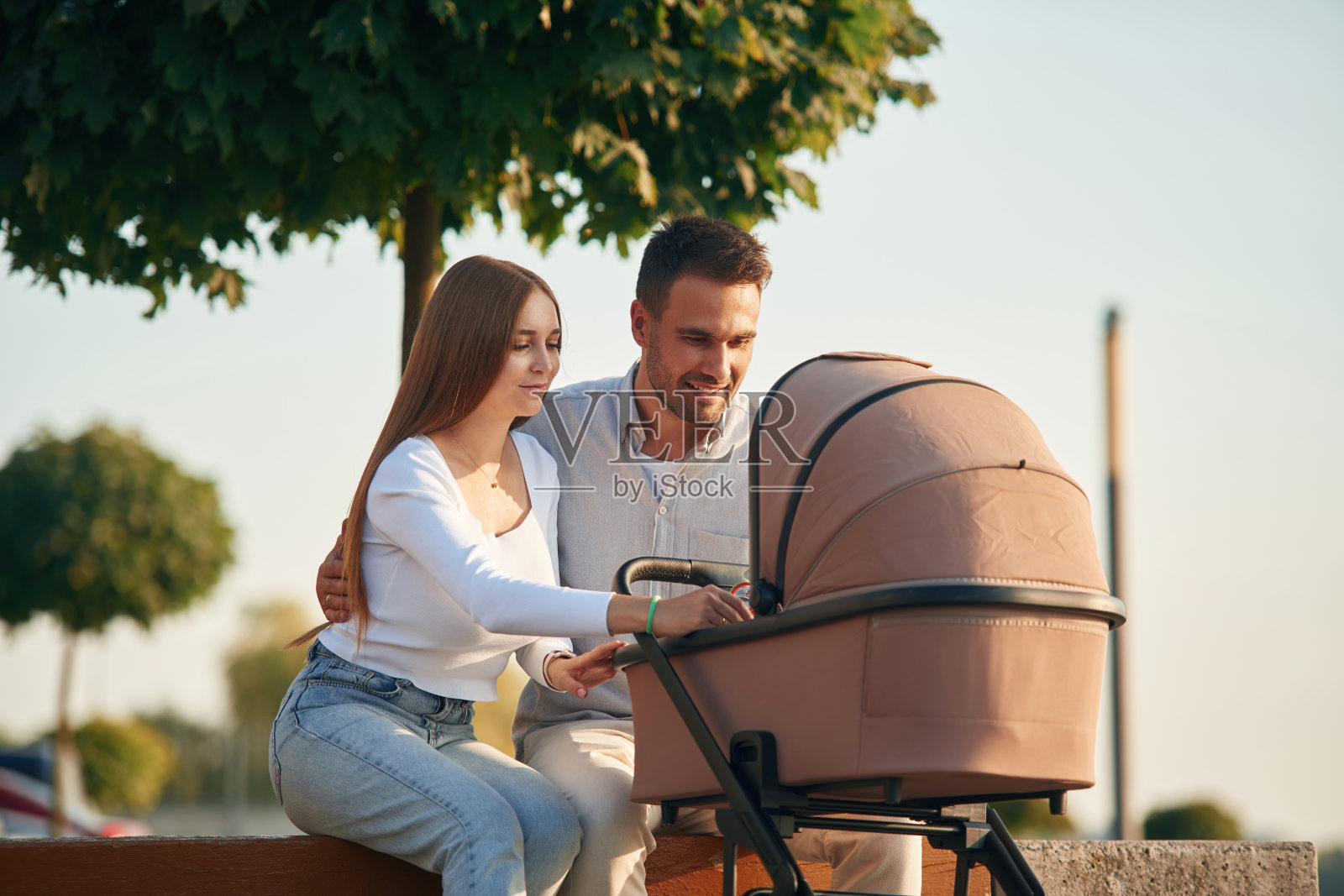 一对年轻夫妇推着婴儿车走在一起照片摄影图片