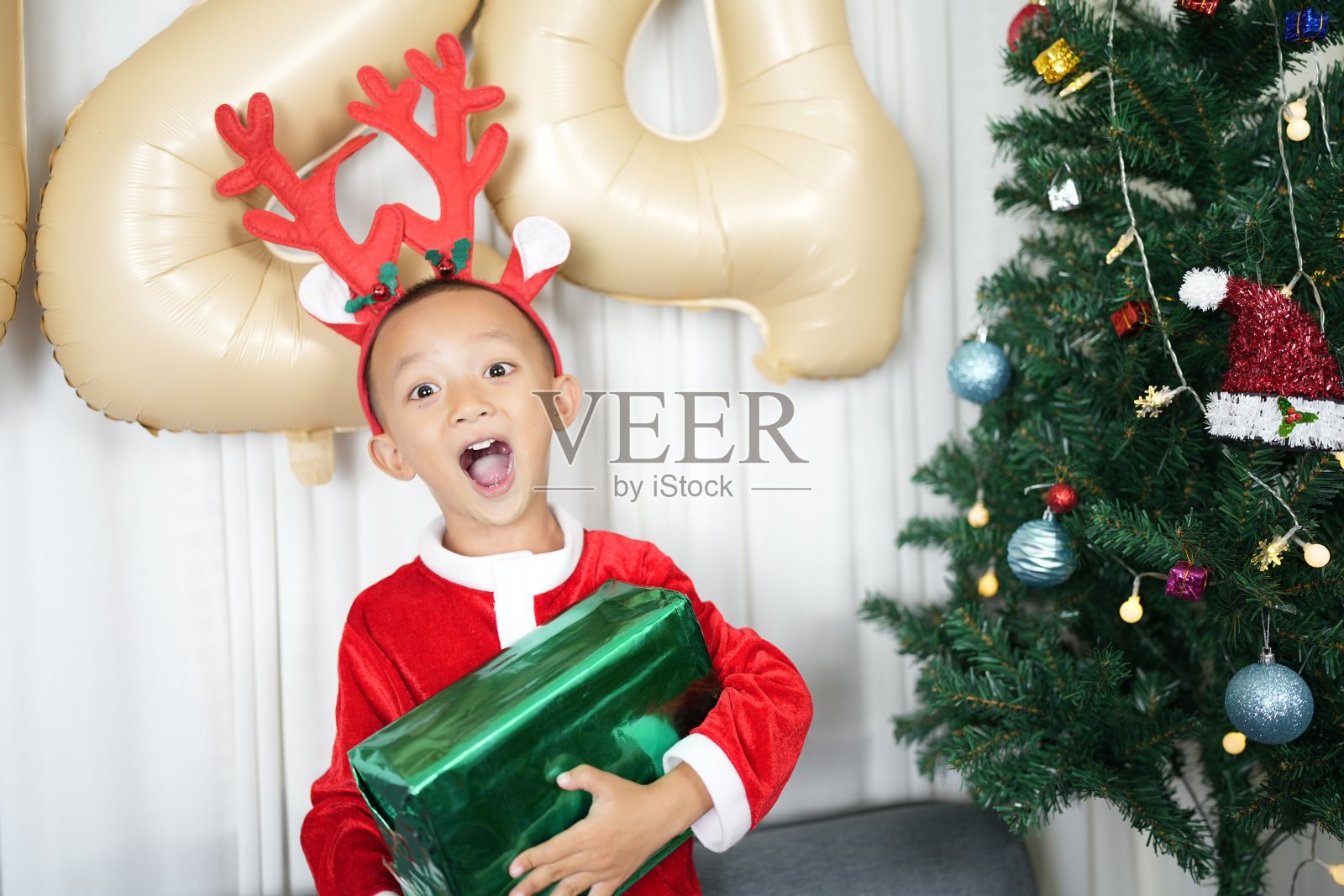 男孩在圣诞节收到妈妈的礼物照片摄影图片