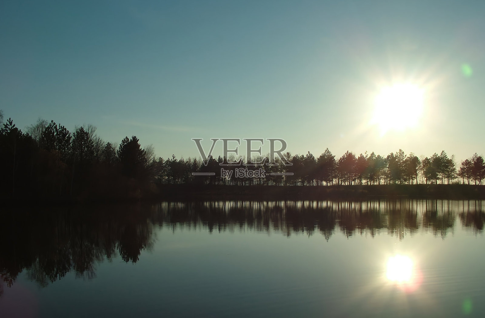 湖泊或池塘的景观野生动物，水面和树木的倒影。秋日的傍晚照片摄影图片