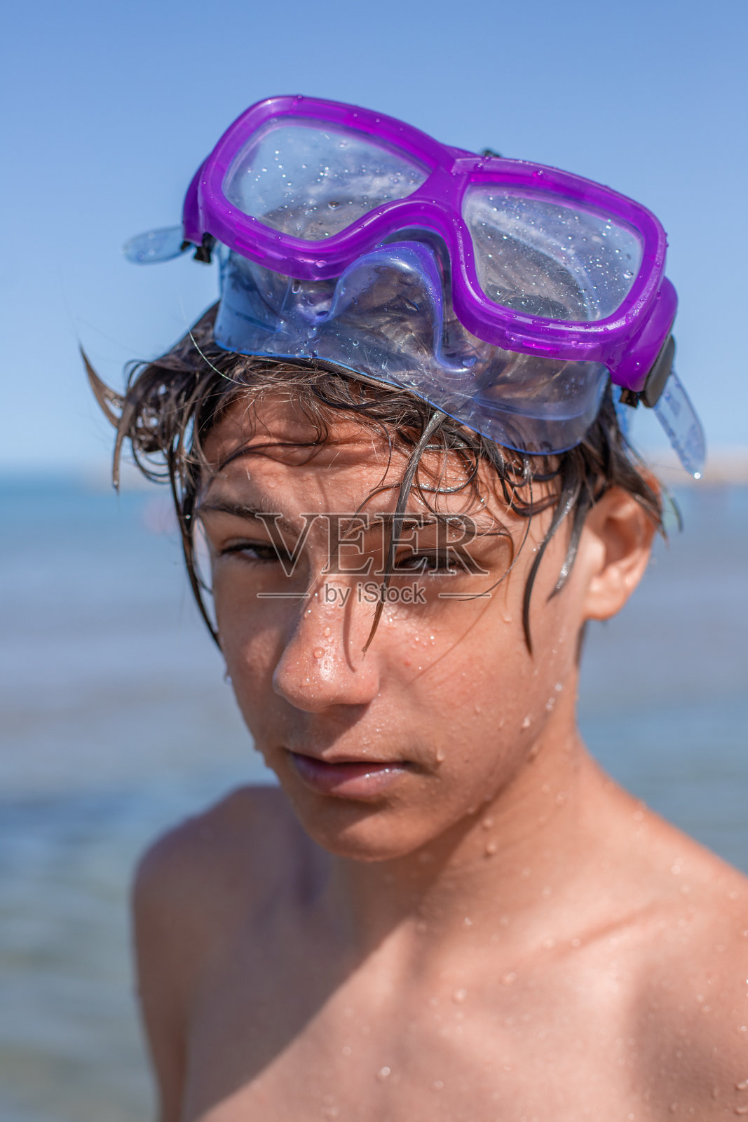 一个英俊的少年带着潜水面具的肖像，捕捉了夏日沙滩上无忧无虑的精神。照片摄影图片