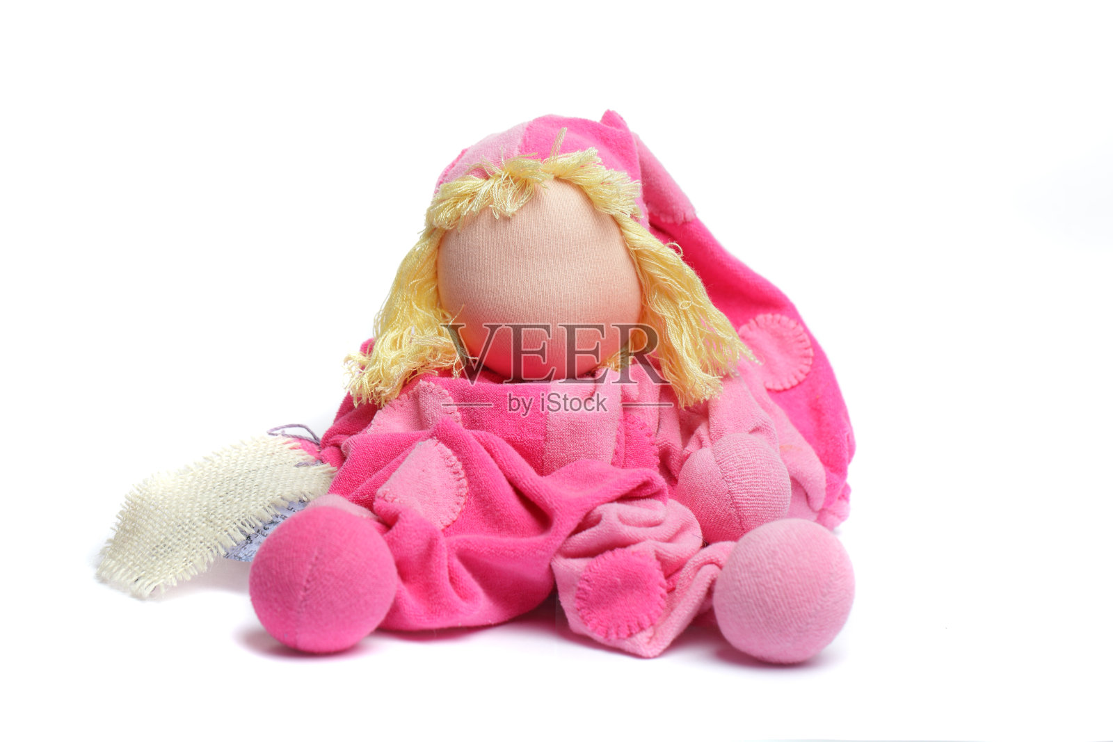 粉红色手工软纺织娃娃玩具白色背景。婴儿玩具照片摄影图片