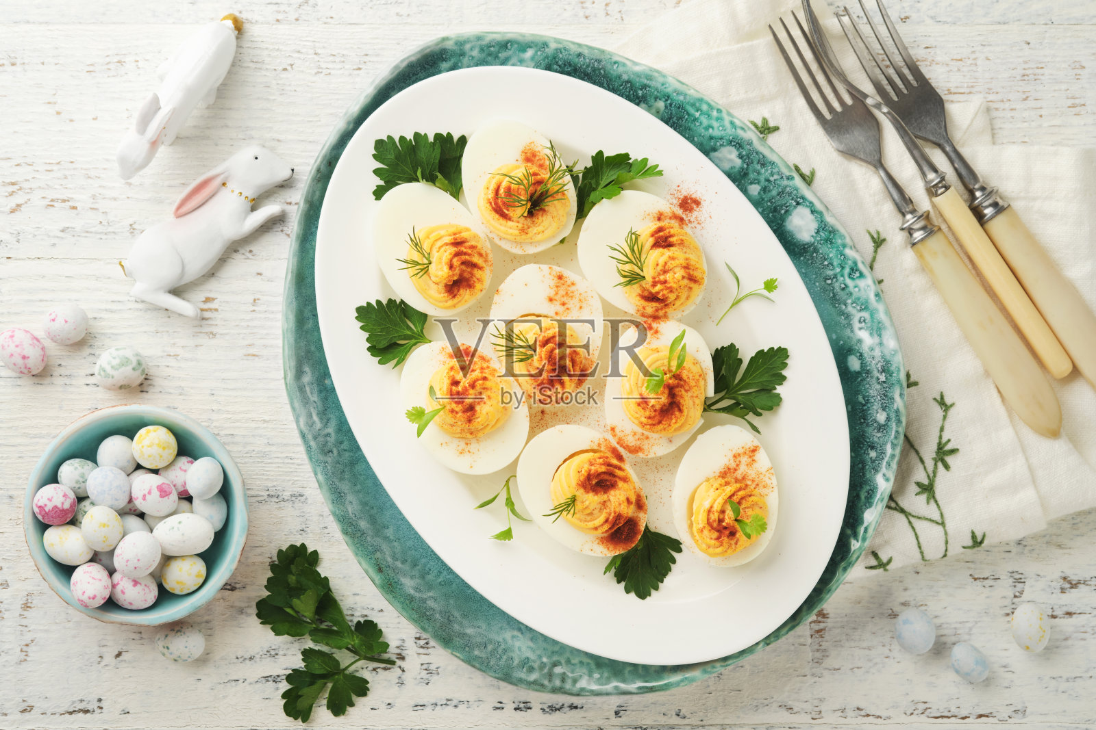 复活节填充蛋。传统的复活节早午餐或晚餐有红辣椒蛋、胡萝卜蛋糕棒和巧克力蛋窝蛋糕。假日装饰的复活节大餐照片摄影图片