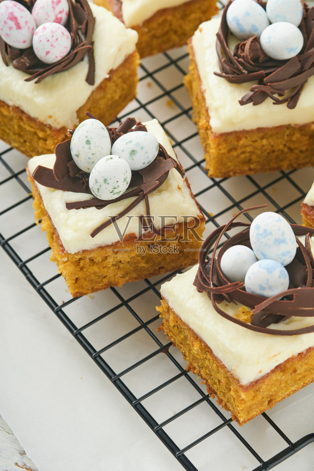 复活节胡萝卜蛋糕棒装饰巧克力窝和巧克力糖蛋开花樱桃或苹果花在乡村轻木制背景。复活节的节日大餐。传统的复活节食物。照片摄影图片