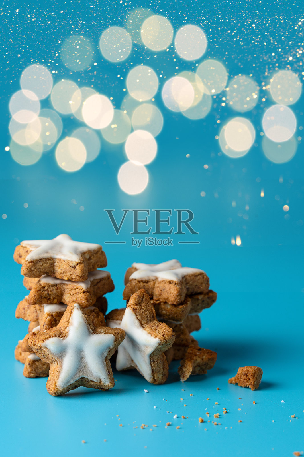姜饼饼干，星形姜饼与糖霜堆叠在蓝色背景与散景照片摄影图片