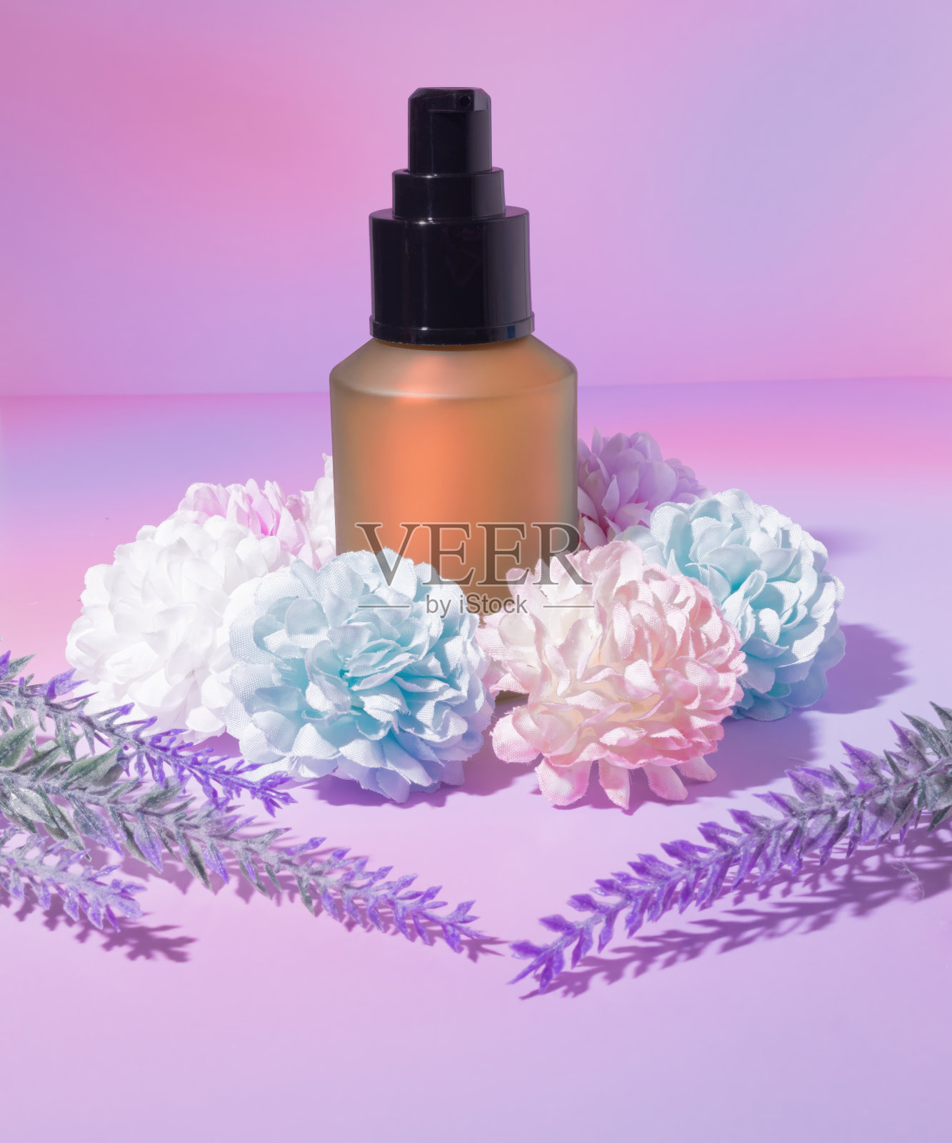 一个美容化妆品包装橙色精华乳液瓶管包围牡丹花和薰衣草小枝在渐变紫色的背景照片摄影图片