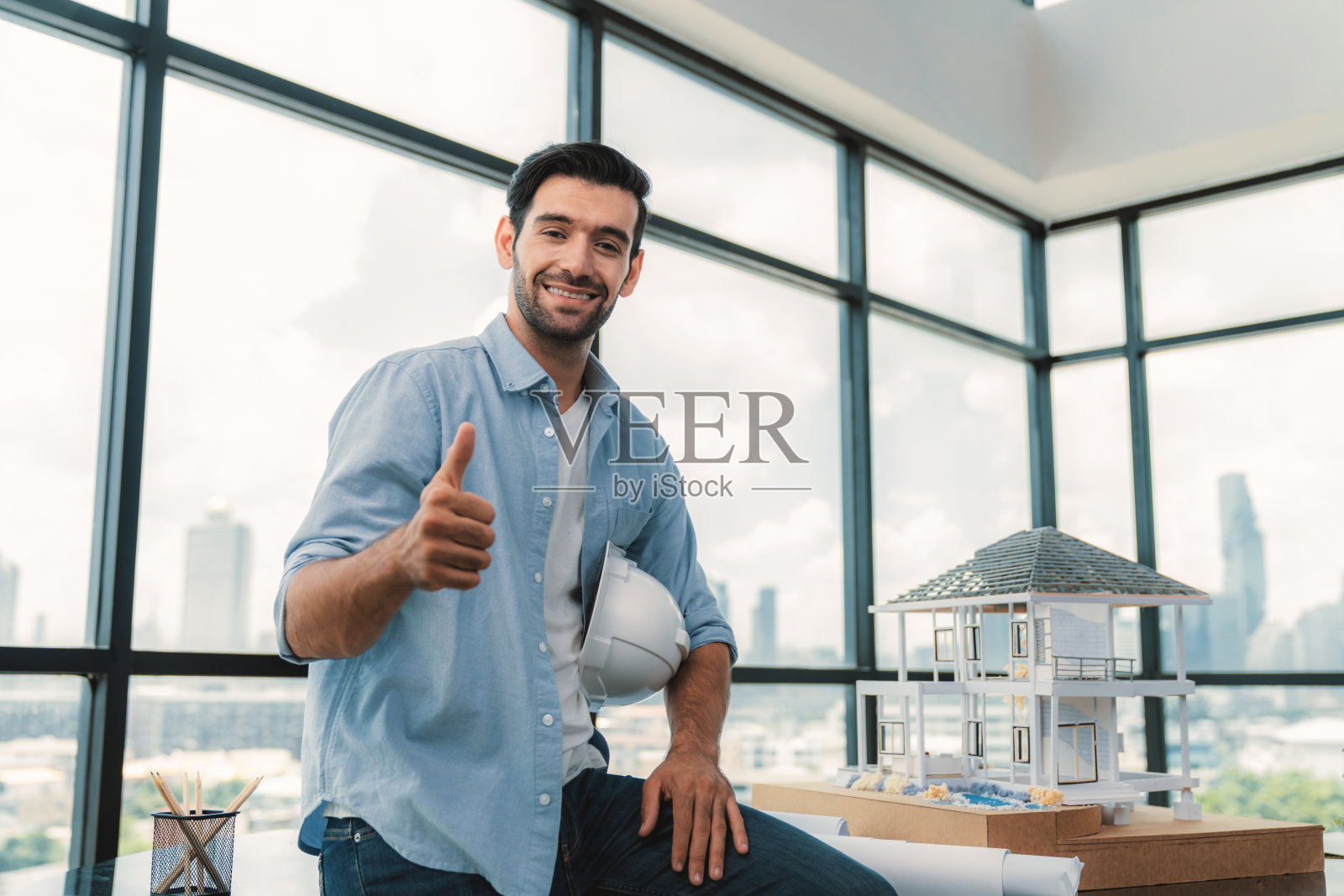 专业工程师带着安全帽看着相机的肖像。窗饰。照片摄影图片