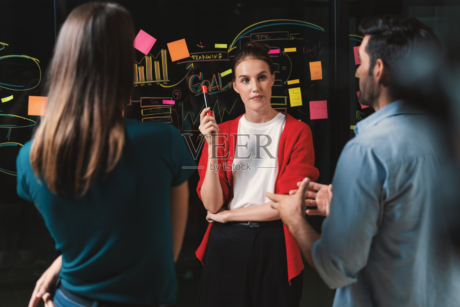 商人们在玻璃墙上讨论，集思广益。窗饰。照片摄影图片