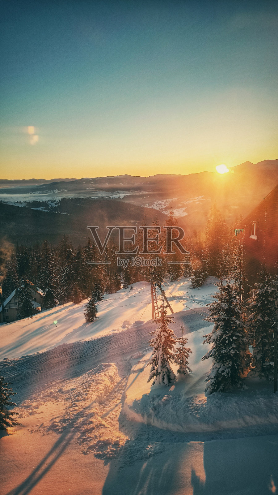 山日出与木屋和冷杉树在前景。冉冉升起的太阳上快速移动的云。喀尔巴阡山脉的风景照片摄影图片