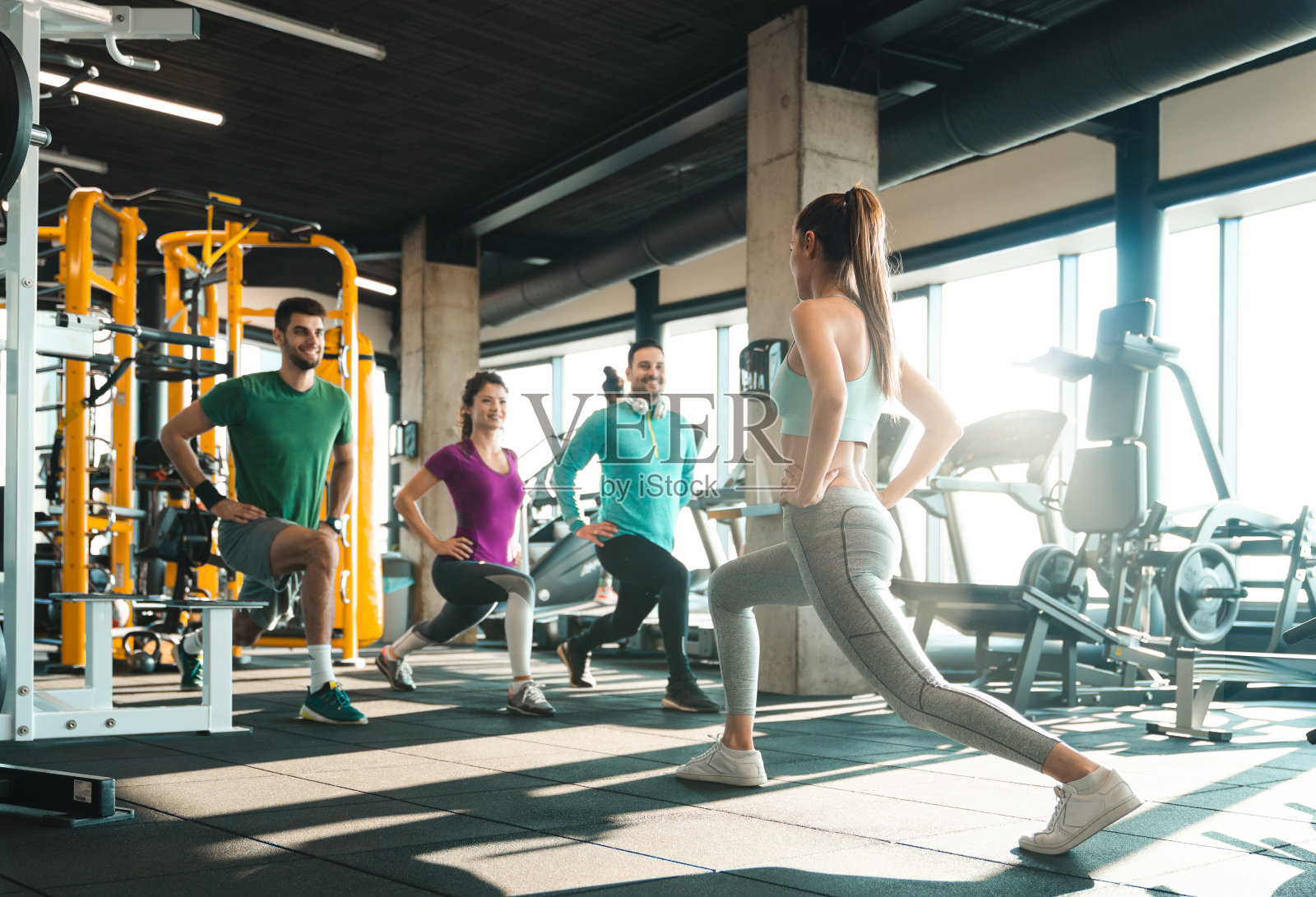 快乐的年轻运动员在健身房做弓步照片摄影图片