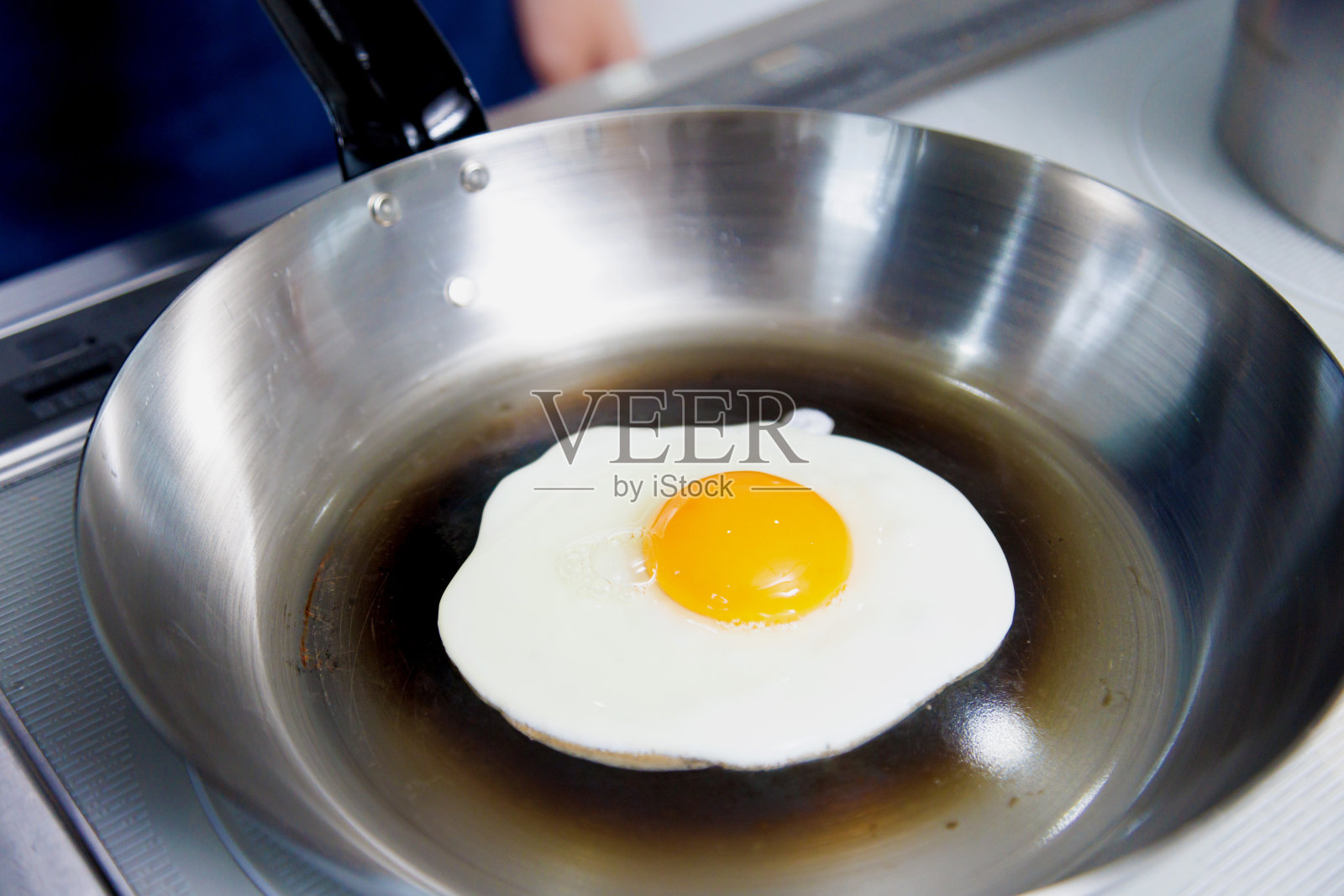 一个女人在厨房里煎鸡蛋照片摄影图片