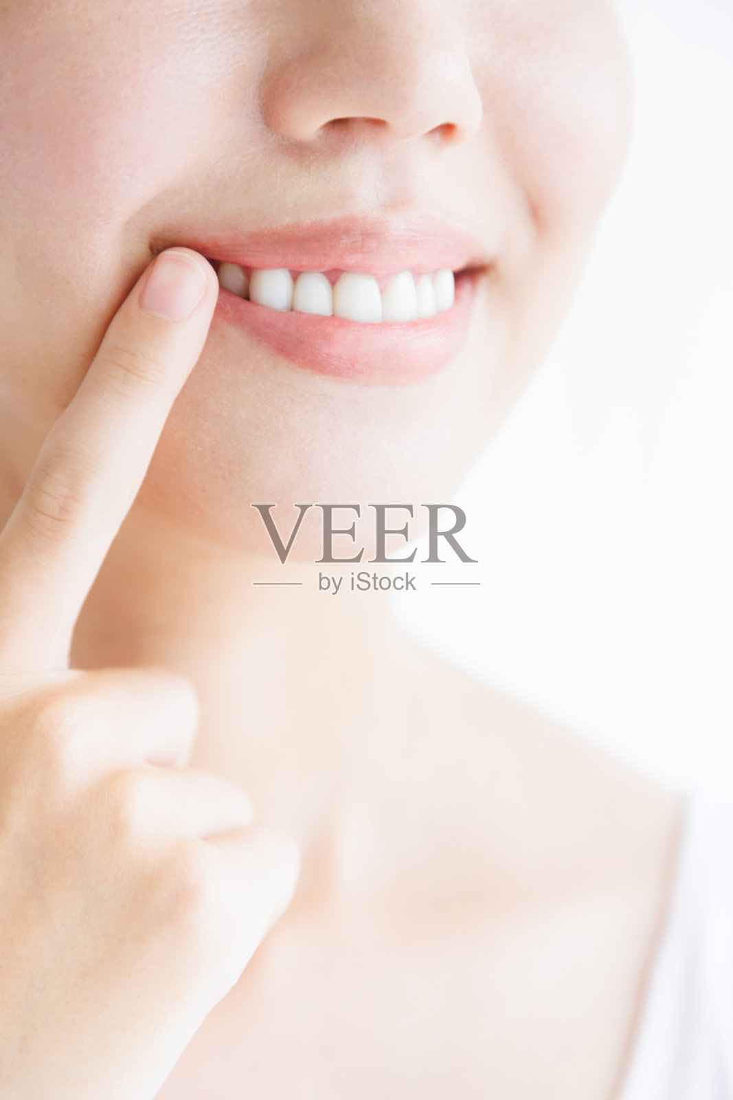 年轻的亚洲女人微笑着露出她的牙齿照片摄影图片