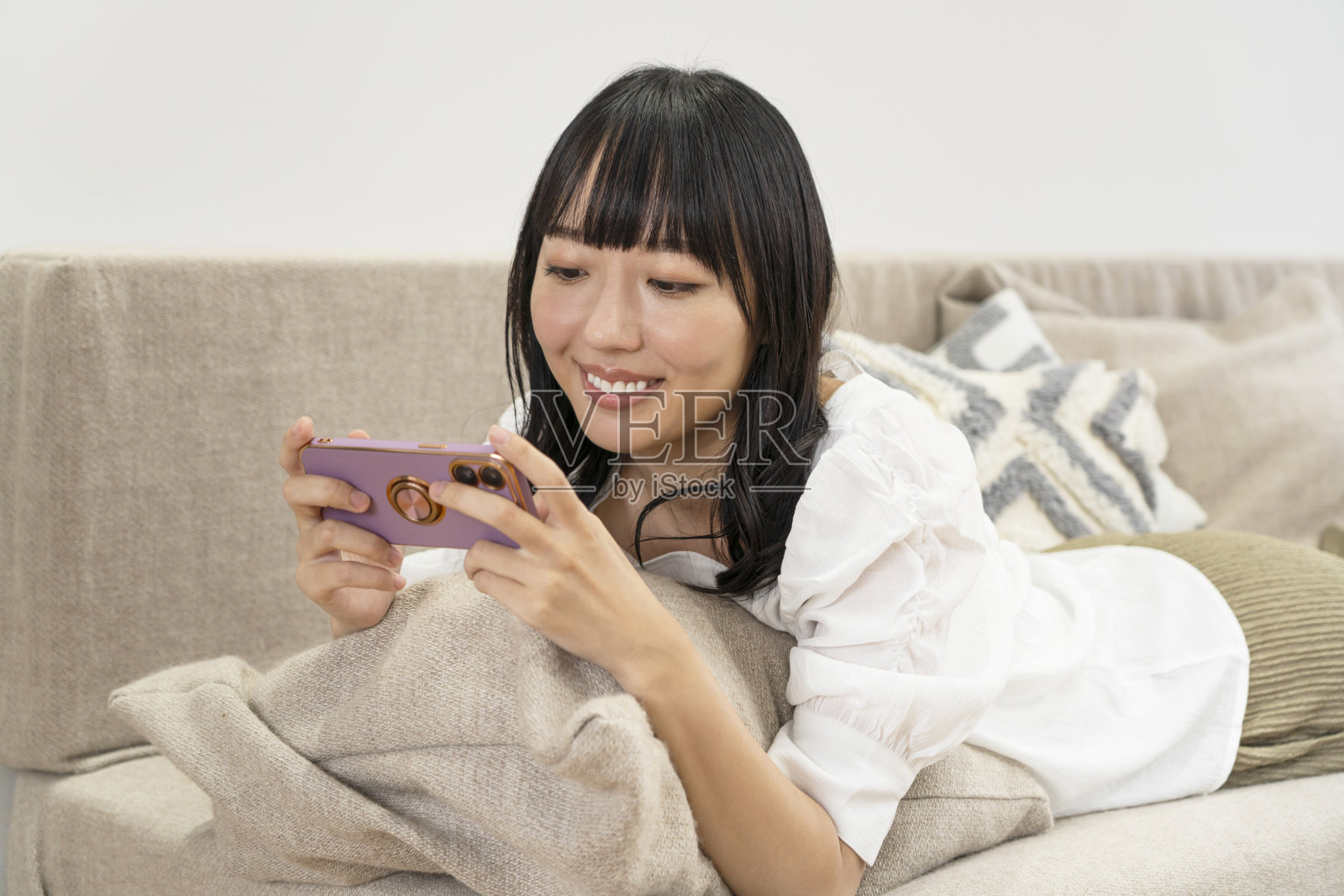 年轻的亚洲女人在家里用手机聊天照片摄影图片