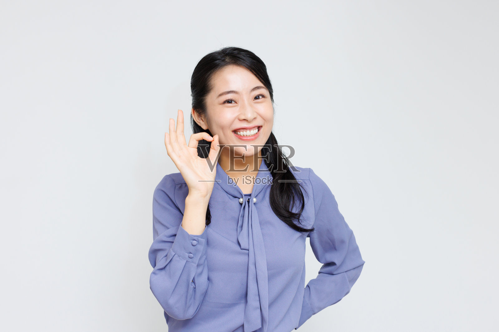 年轻的亚洲女人在做“好”的手势照片摄影图片