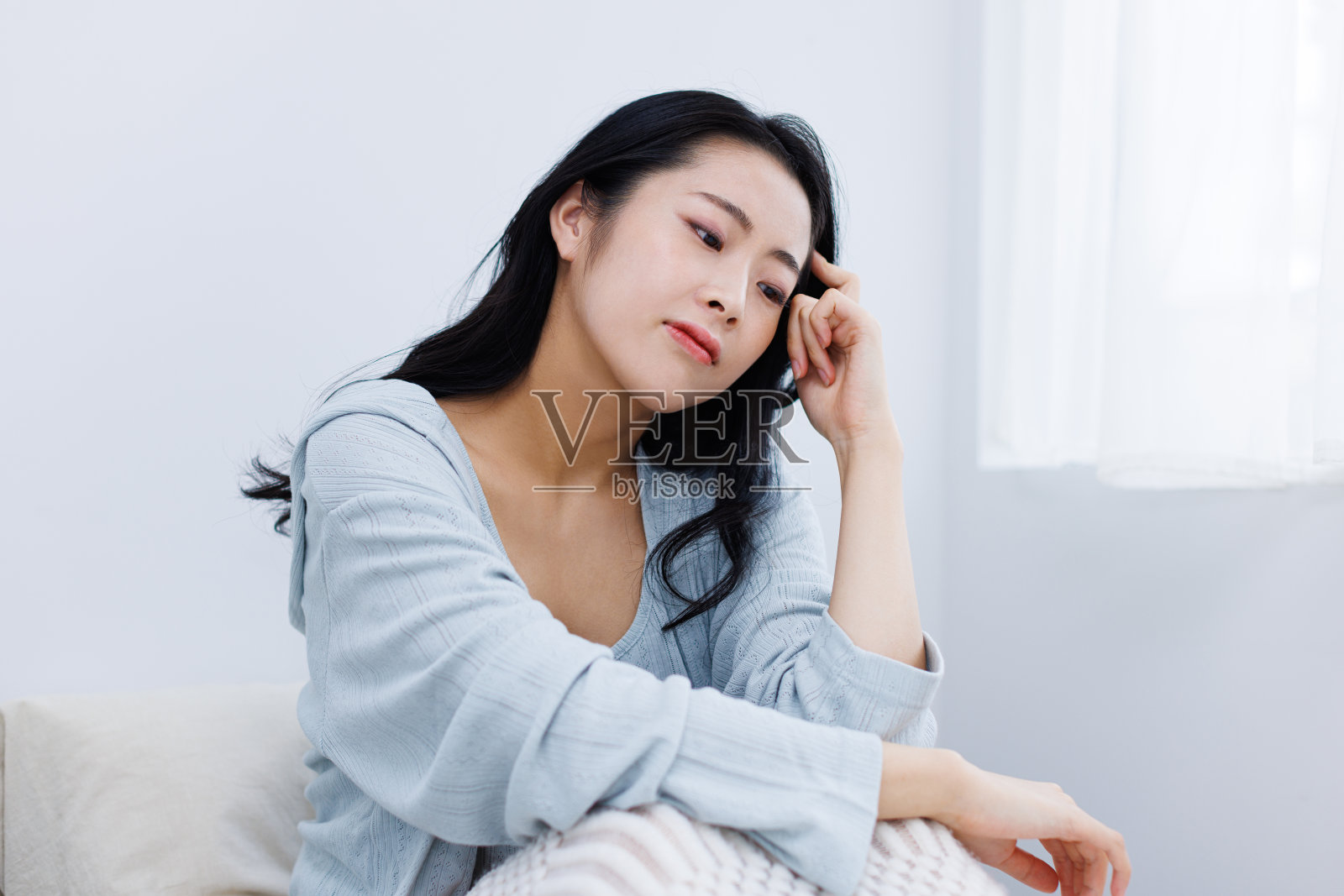 年轻的亚洲女性在床上感到沮丧照片摄影图片