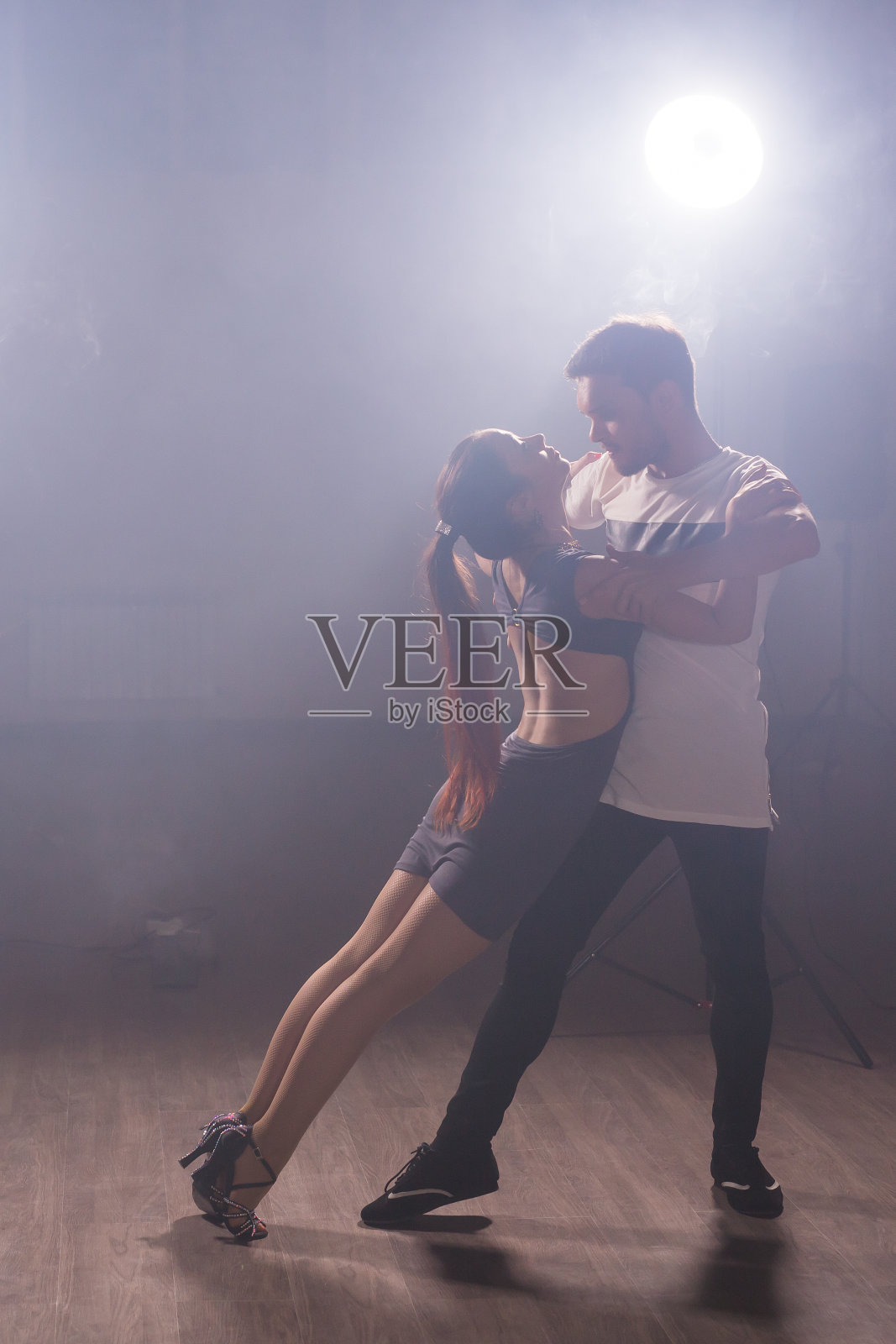 年轻情侣跳拉丁舞，巴塔塔舞，梅伦格舞，萨尔萨舞。两个优雅的姿势在舞蹈课上复制空间和空白的文字空间照片摄影图片