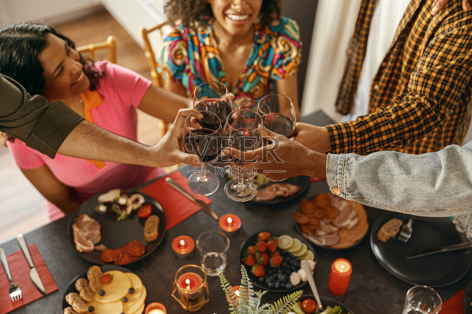 快乐的朋友们在家里喝着酒，碰杯，开着节日派对照片摄影图片