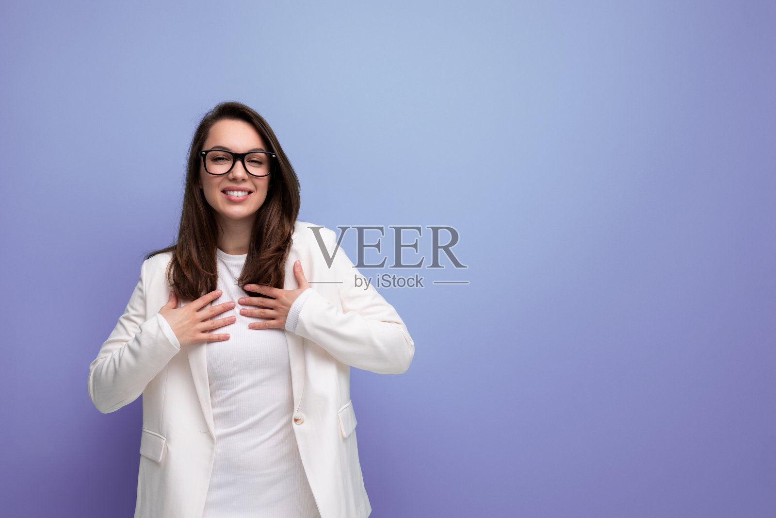 聪明的女人，浓密的黑发，白色的衣服，在工作室背景照片摄影图片