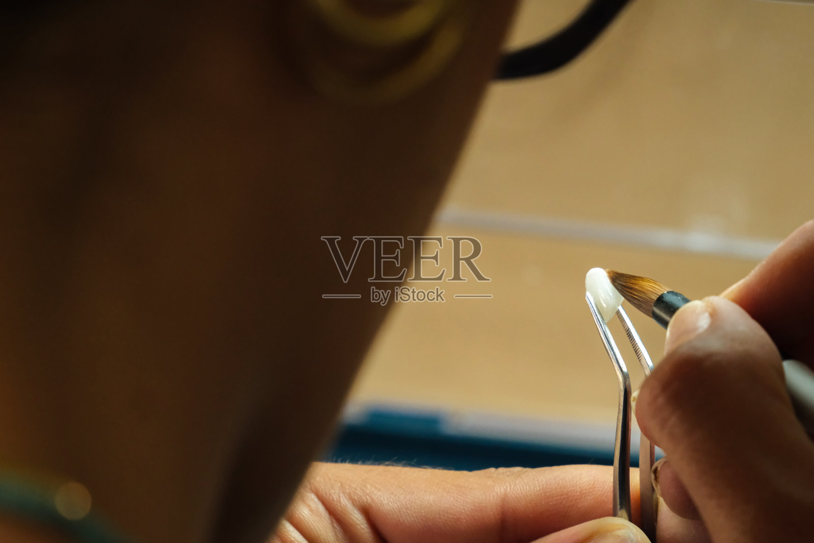 熟练的牙科技师给牙齿上色照片摄影图片