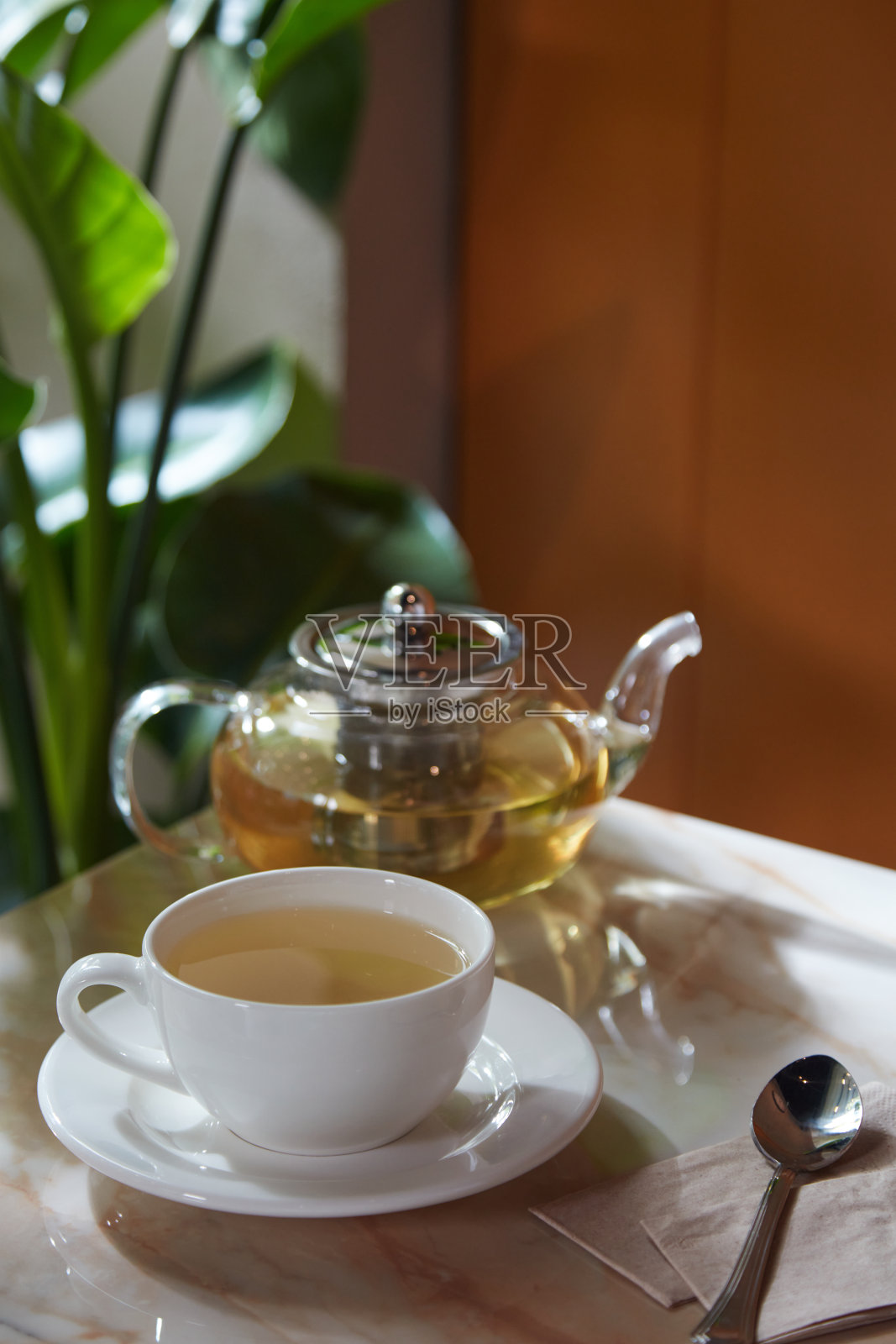 一杯凉茶，桌上放着一个玻璃茶壶照片摄影图片