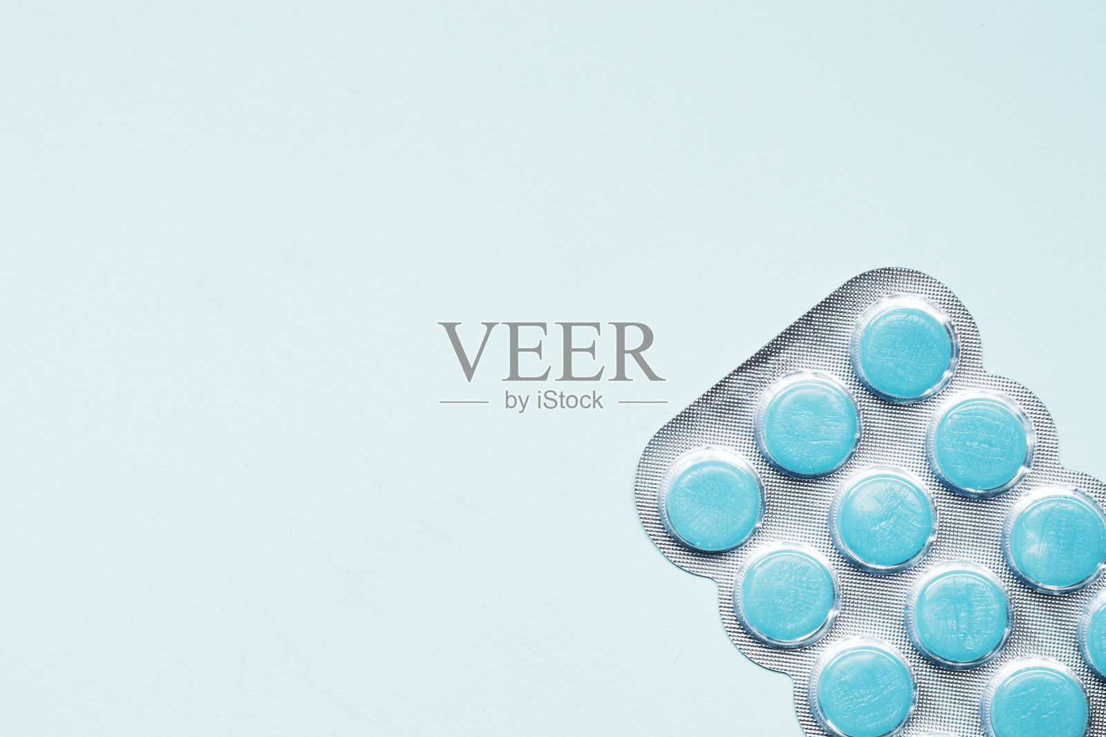 水泡与蓝色背景的彩色咳嗽滴。 医学概念。照片摄影图片