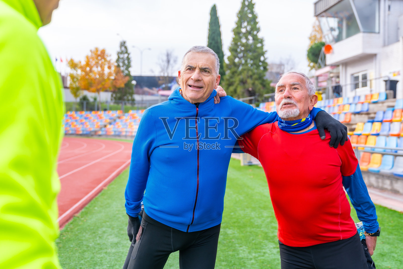 成熟的男人在田径跑道上伸展身体照片摄影图片