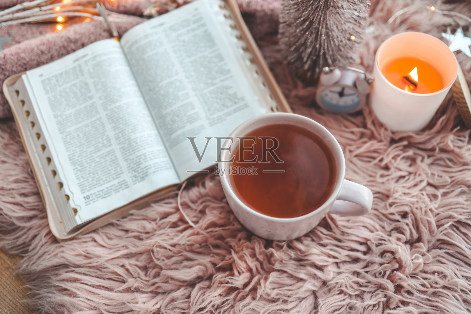 打开圣经在舒适的粉红色的冬季家庭早晨的气氛照片摄影图片