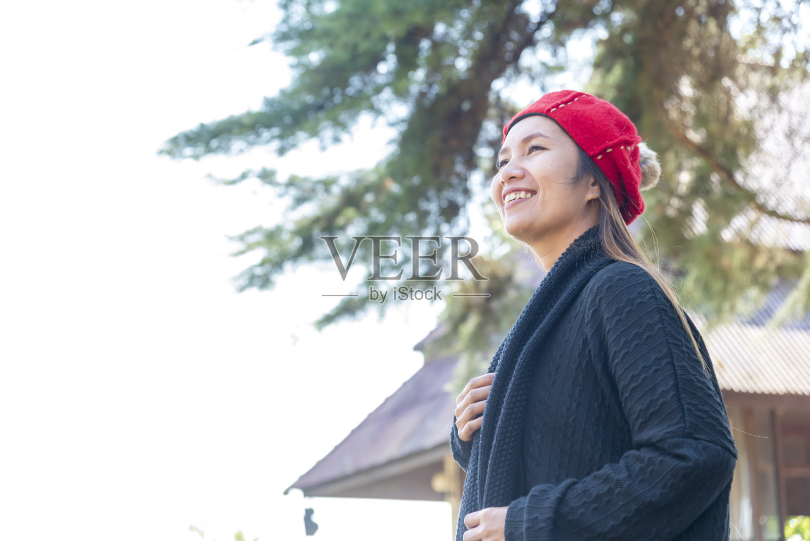 图为在绿色公园放松的亚洲妇女。快乐放松的亚洲女人在户外花园微笑的脸。年轻女性享受自然自由的生活方式。绿意盎然，室外幸福，大自然美景。照片摄影图片