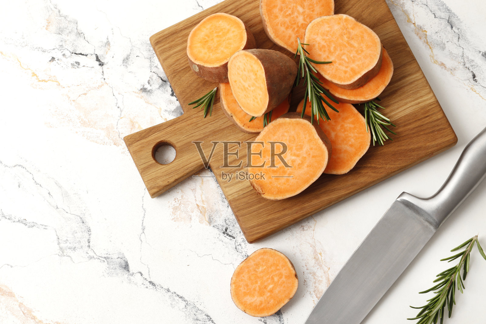 新鲜成熟的红薯和迷迭香香料在大理石背景的餐桌上组成照片摄影图片