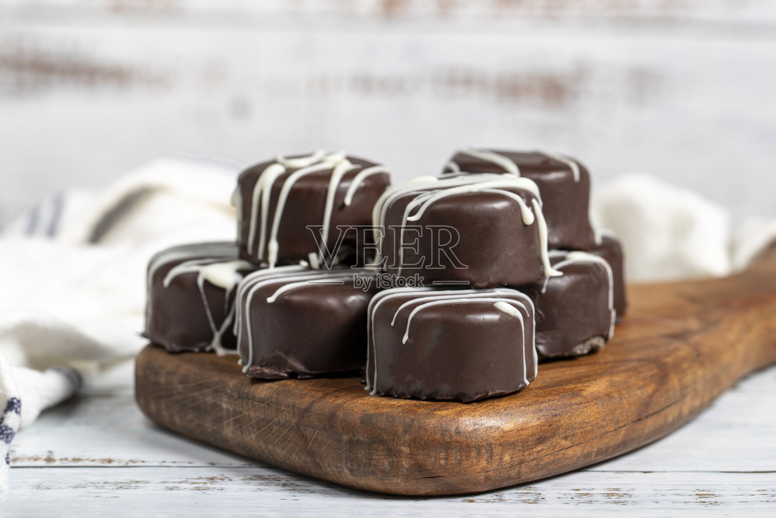 巧克力饼干。美味的曲奇，里面是椰子，外面是巧克力，木质背景。法式蛋糕店的产品。近距离照片摄影图片