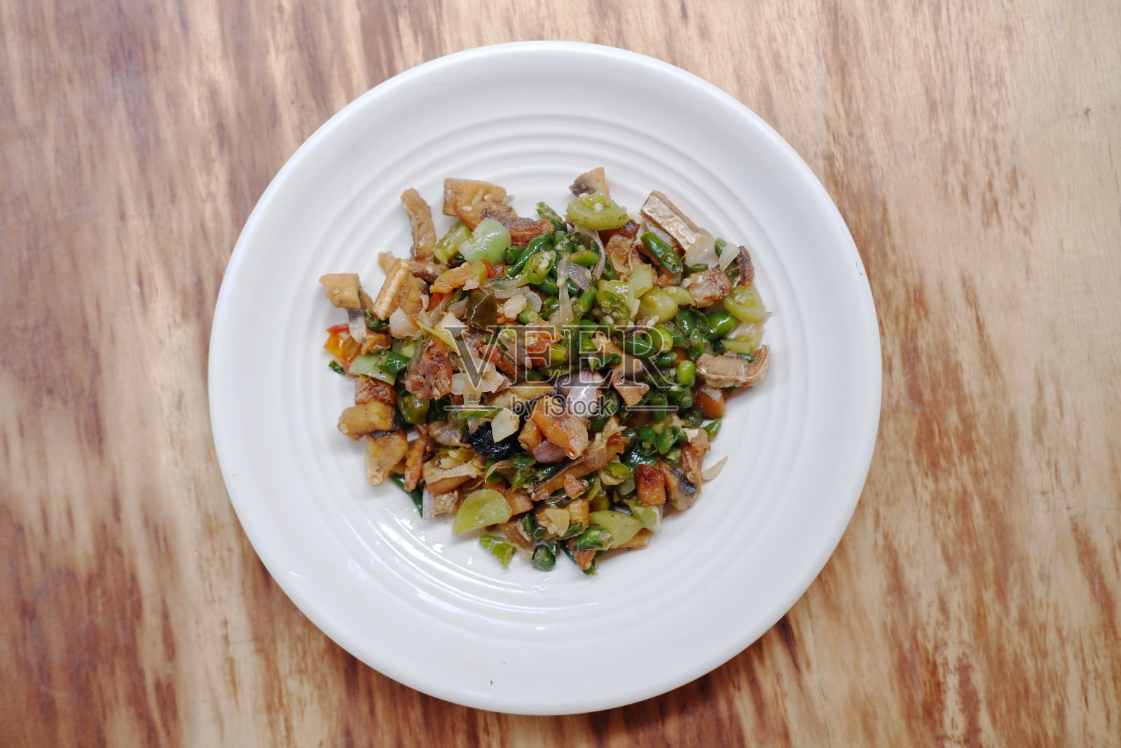 印尼传统食品“Tumis ikan asin jambal roti chili ijo”在木背景上用青椒炒ikan asin jambal roti照片摄影图片