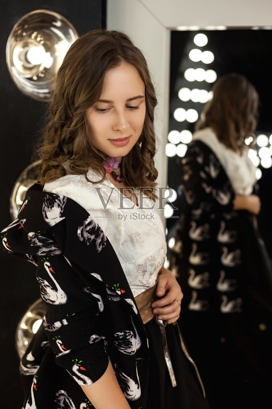 沉思完美的封面女人在时尚的形象，在黑色的工作室里对着镜子摆姿势，思考的样子。成人时尚女士模特在优雅的衣服在黑暗中。时尚的风格理念。复制广告文本空间照片摄影图片