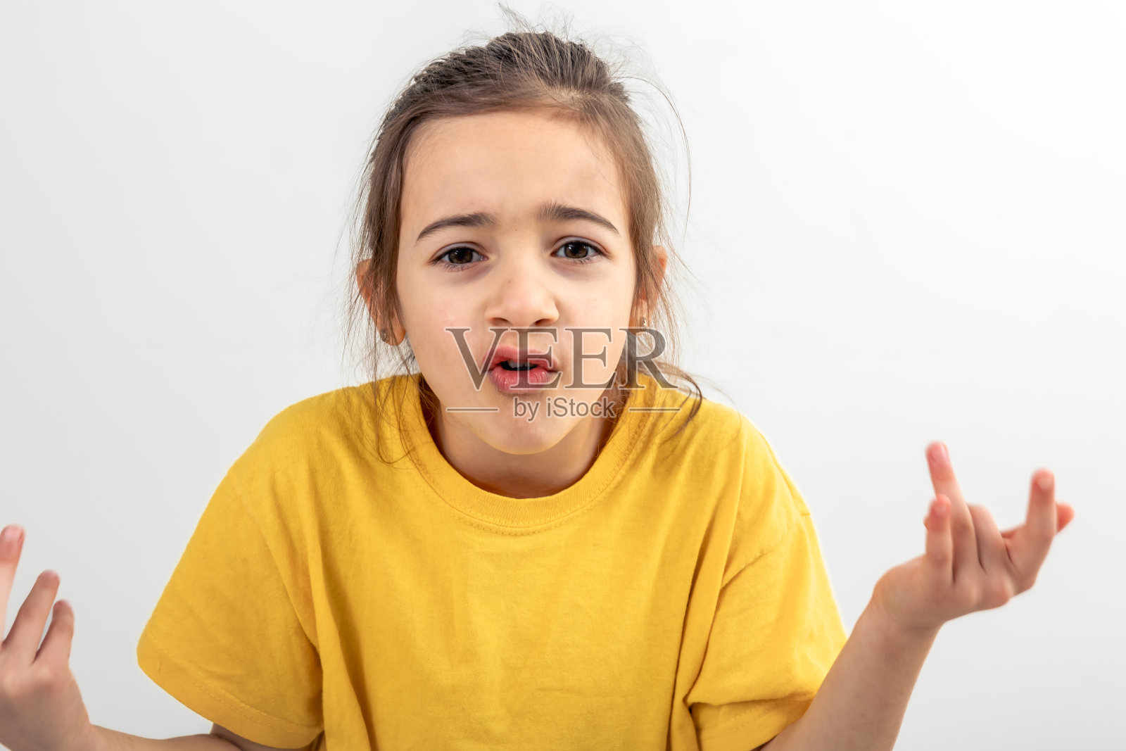 惊讶的小女孩举起她的双手，孤立在一个白色。照片摄影图片