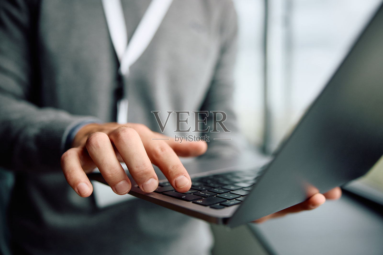 企业家在办公室工作时使用笔记本电脑的特写。照片摄影图片