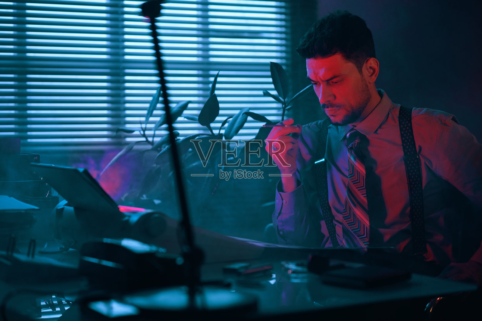 一个沉思的年轻人手里拿着铅笔在翻阅文件照片摄影图片