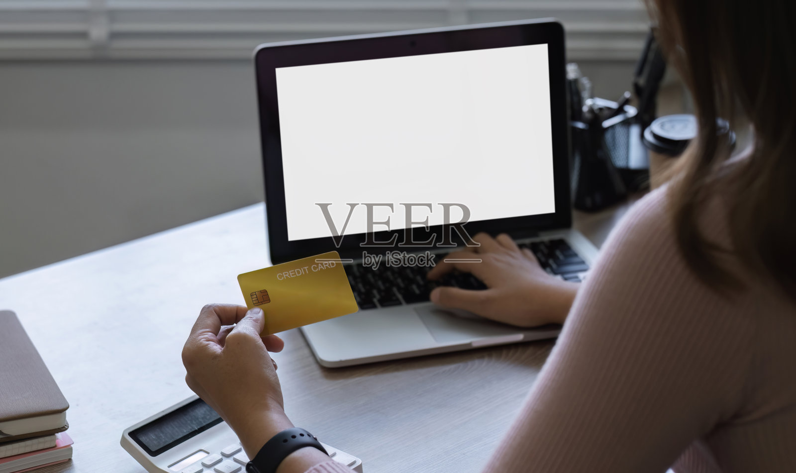 年轻女性拿着信用卡，用笔记本电脑在网上购物或网上理财照片摄影图片