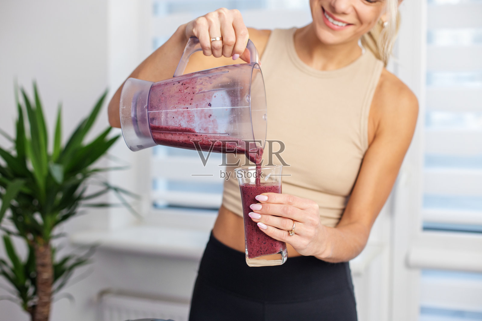 健康食品理念。在家厨房做奶昔的女人。照片摄影图片