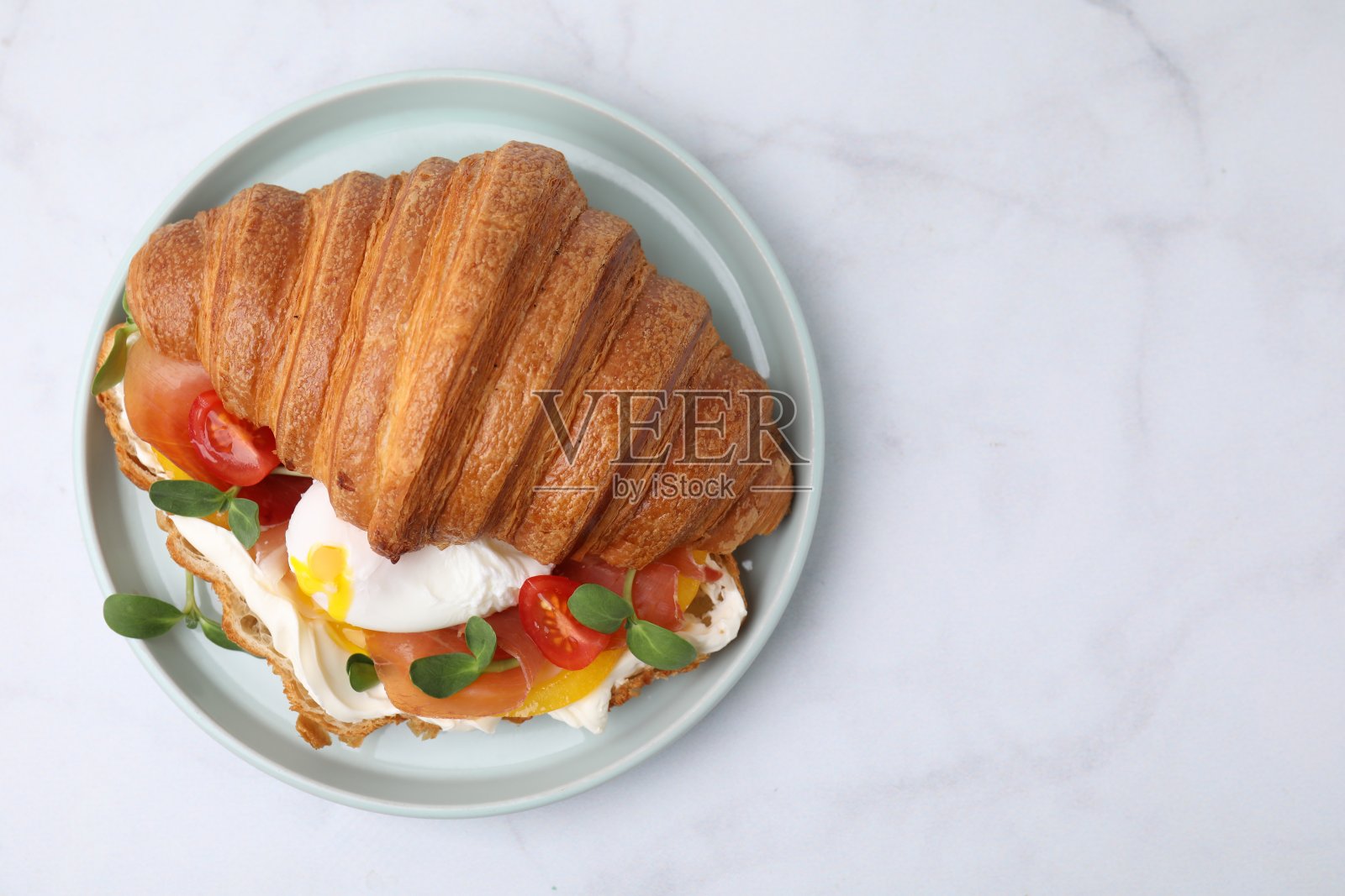 白色餐桌上美味的牛角面包配煎蛋、番茄和蔬菜，俯视图。文本空间照片摄影图片