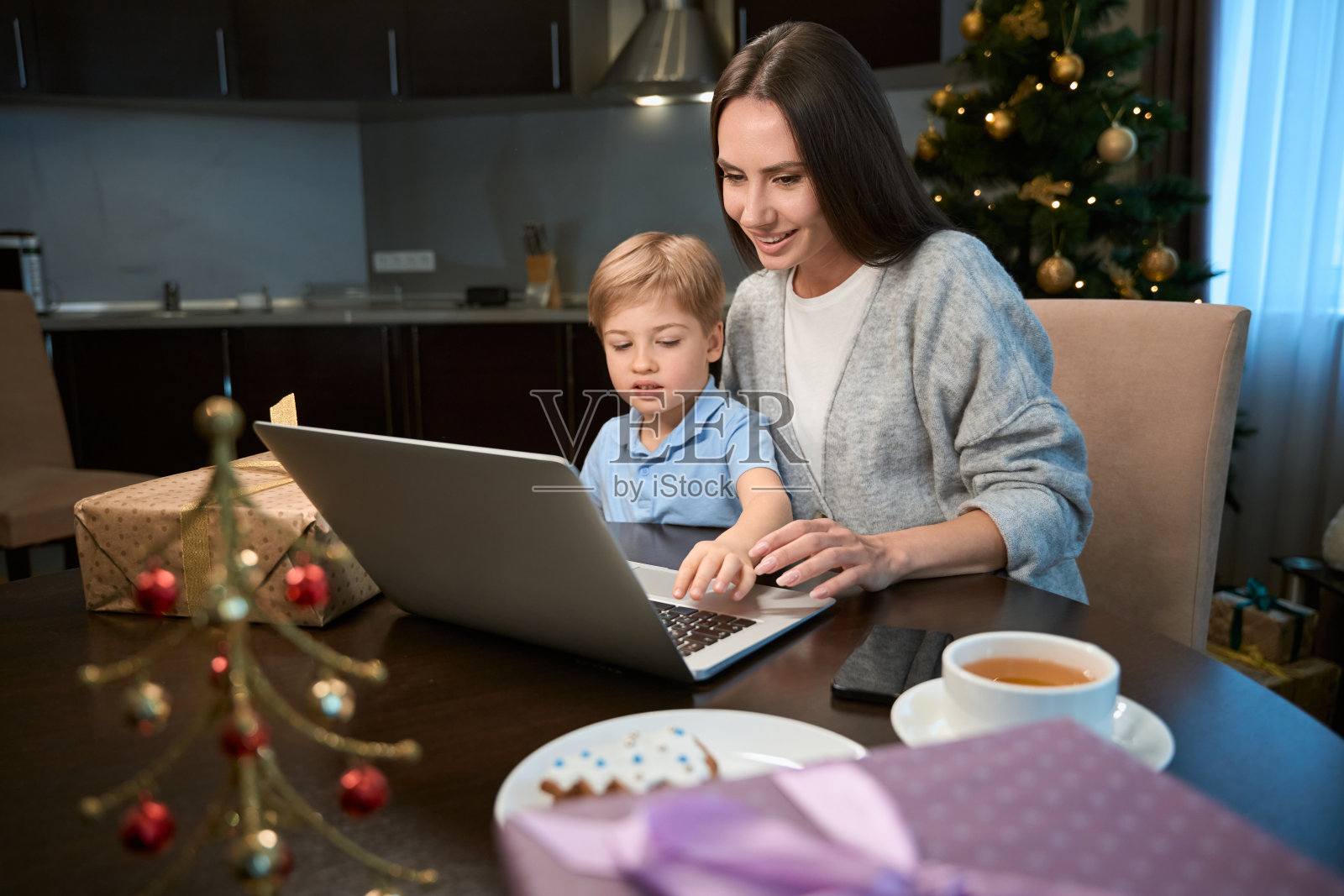 带着孩子的女商人寒假在家用笔记本电脑工作照片摄影图片
