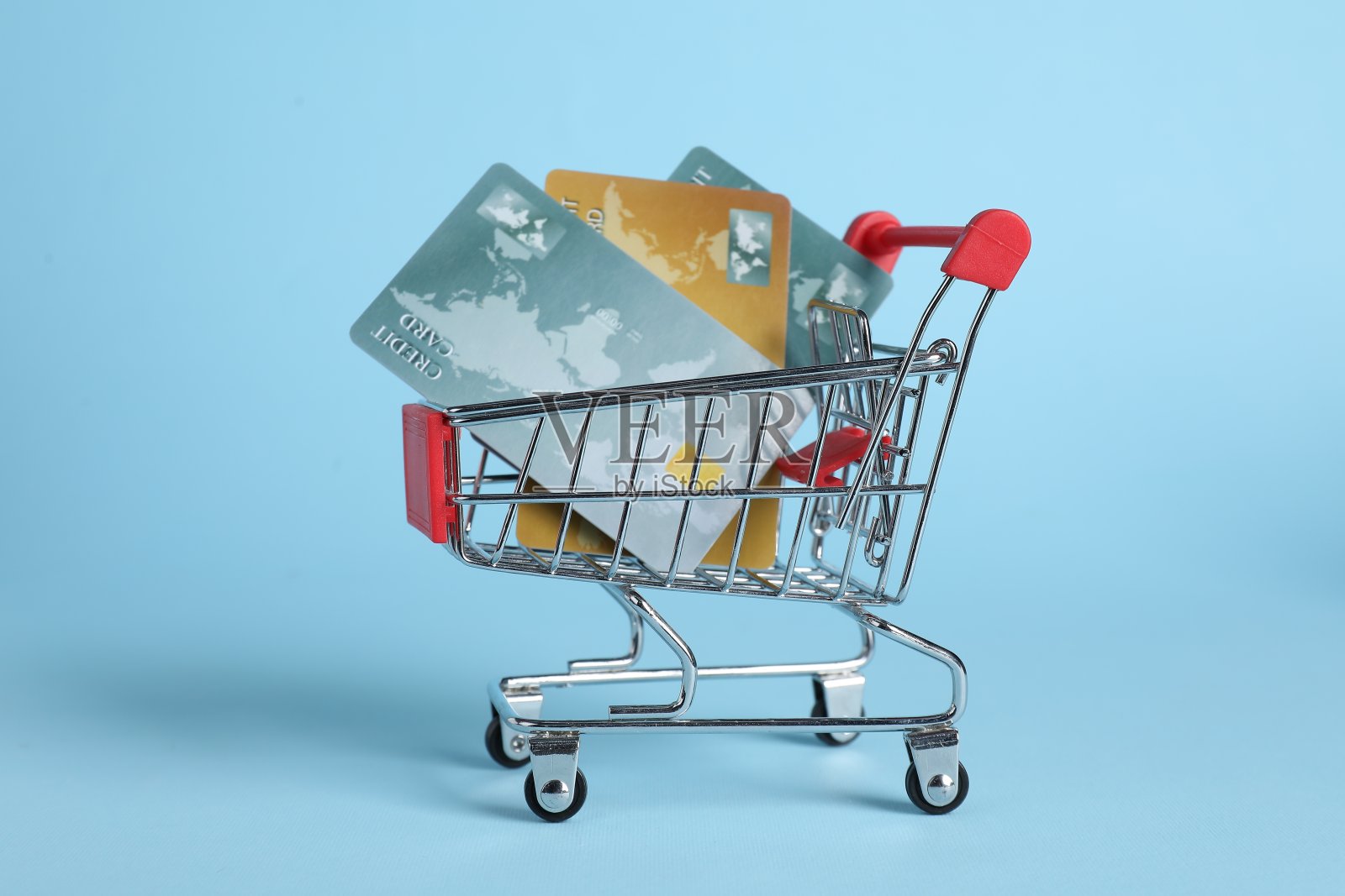 小金属购物车与信用卡在浅蓝色的背景照片摄影图片