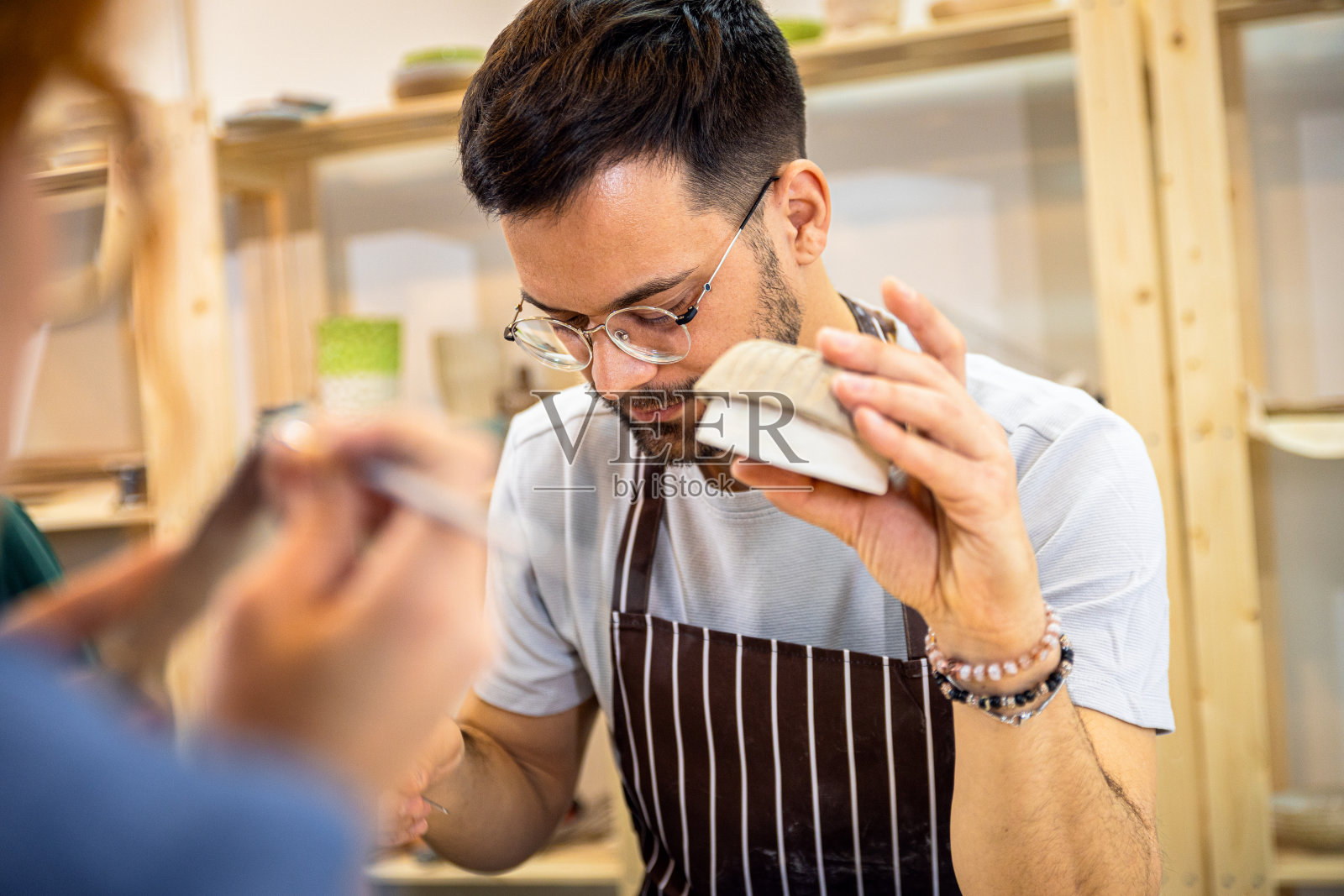 一名男子在陶艺工作室用粘土制作碗。照片摄影图片