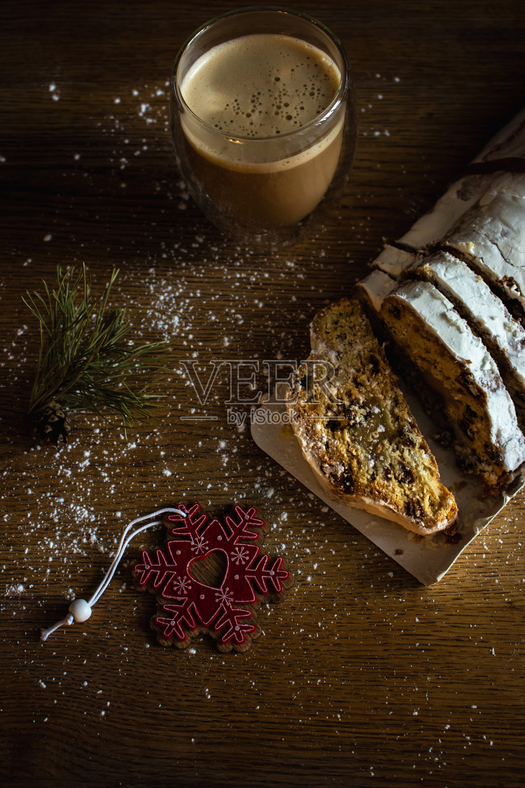 圣诞节偷咖啡杯和装饰玩具。甜圣诞面包与可可和糖粉。新年装饰。节日餐桌上的自制葡萄干偷面包。照片摄影图片