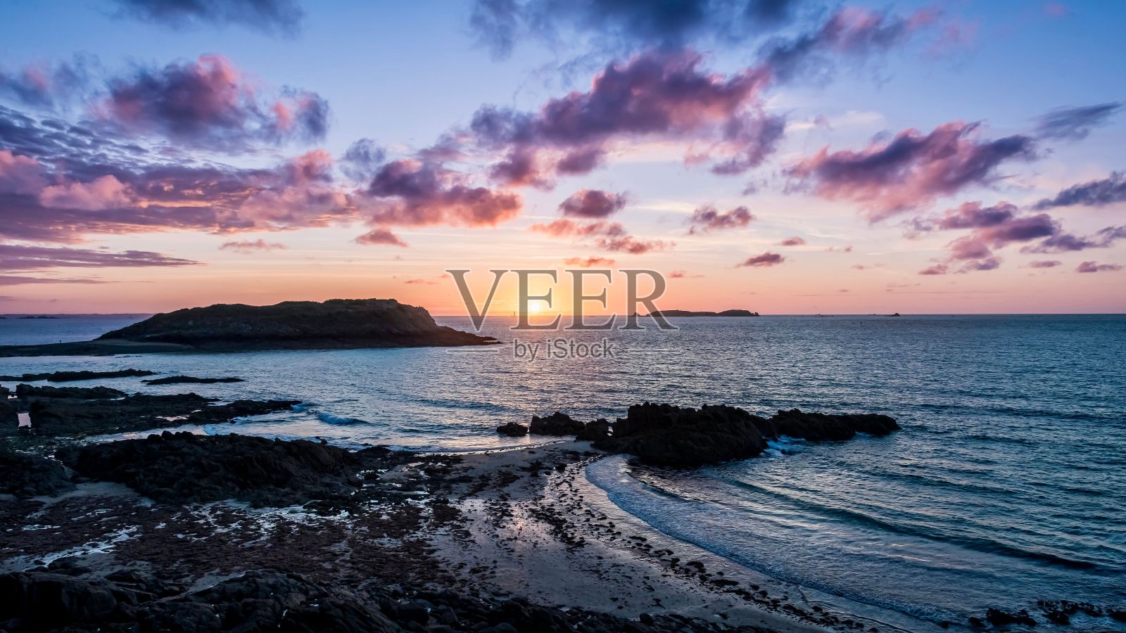 在法国圣马洛，田园诗般的海滩上，金色日落的景色如画照片摄影图片