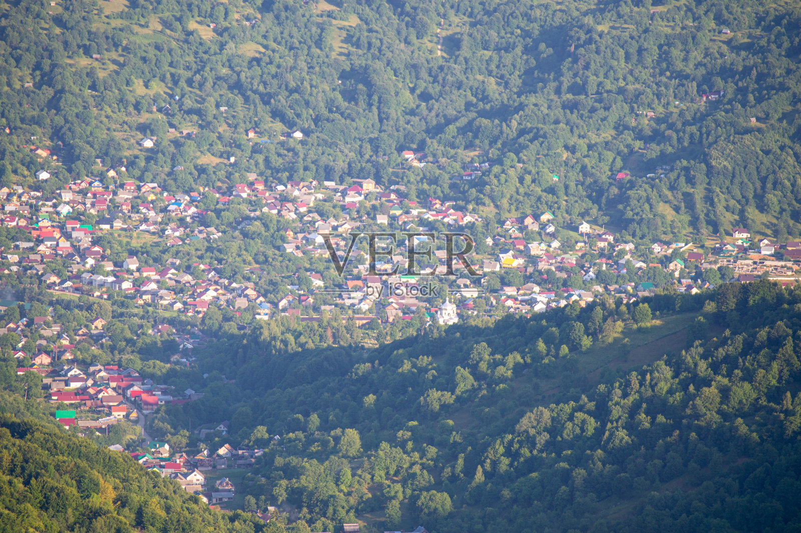 日落时绿色草地上的山景照片摄影图片