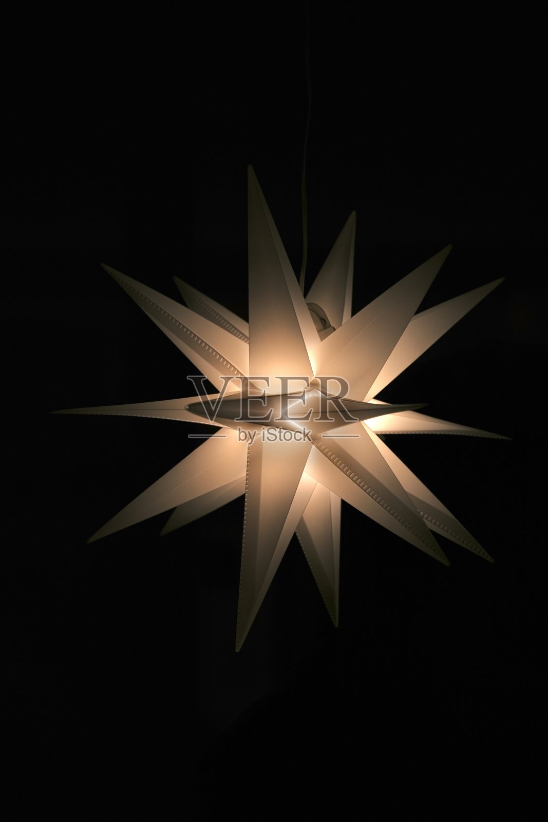 在黑色背景下悬挂的单色圣诞星星照片摄影图片