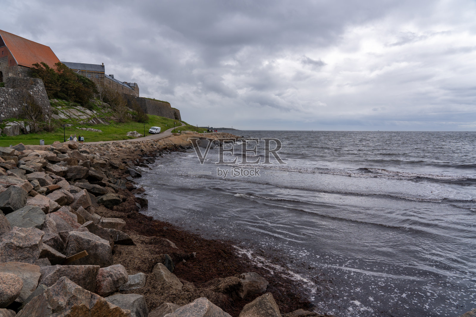 在瑞典，一股温和的水流从岩石和保护海堤上倾泻而下的宁静景象照片摄影图片